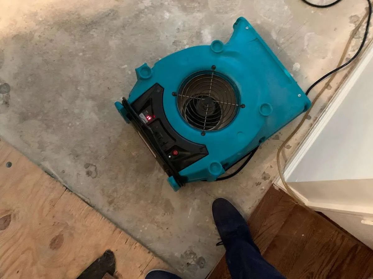 Air mover drying subfloor during Commercial Water Damage Restoration in Cushing